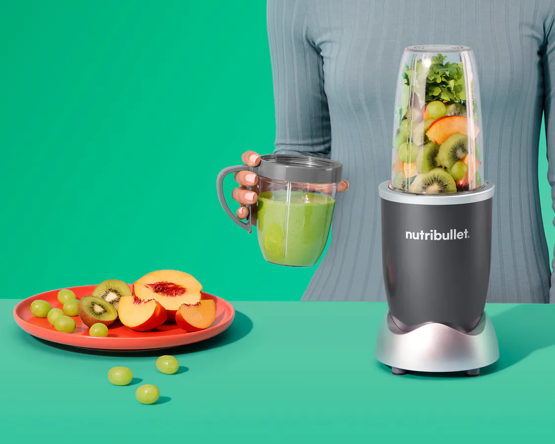 nutribullet original with cup on green background.